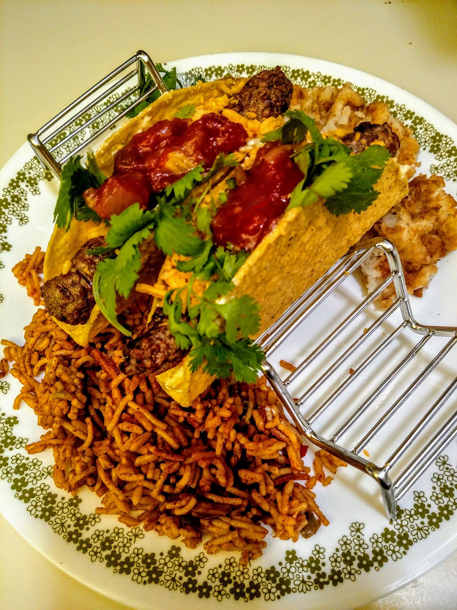 Breakfast of eggs shambled with cream cheese and shredded Mexican blend, turkey sausage, cilantro and salsa in taco shells