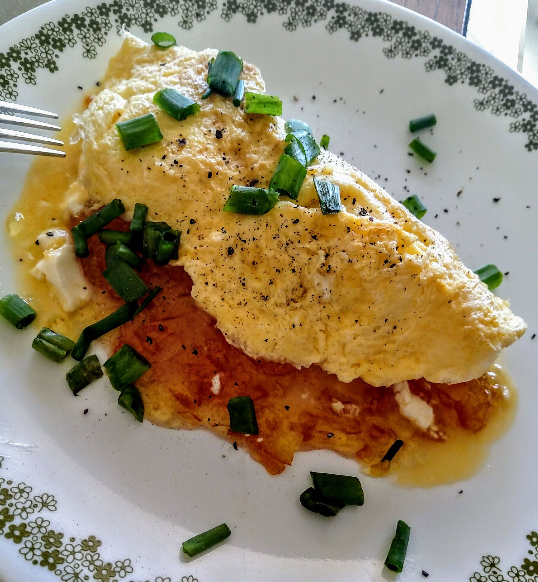 four egg omelet, filled with cream cheese, orange marmalade, orange zest and covered in green onion tips (chives) with fresh cracked pepper - your welcome