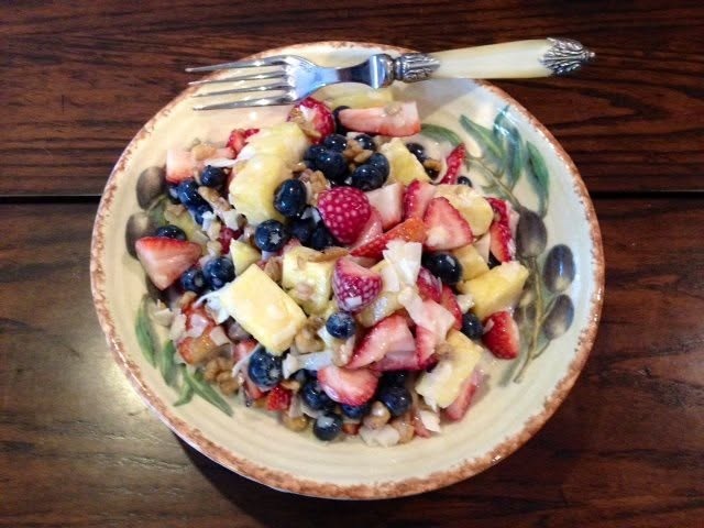 Chilled summer salad, all fresh ingredients - blueberries, strawberries. pineapple. coconut, walnuts, yogurt, local homey and a dash of fresh vanilla
