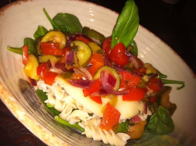 Rice pasta on organic fresh spinach with a pepper melody